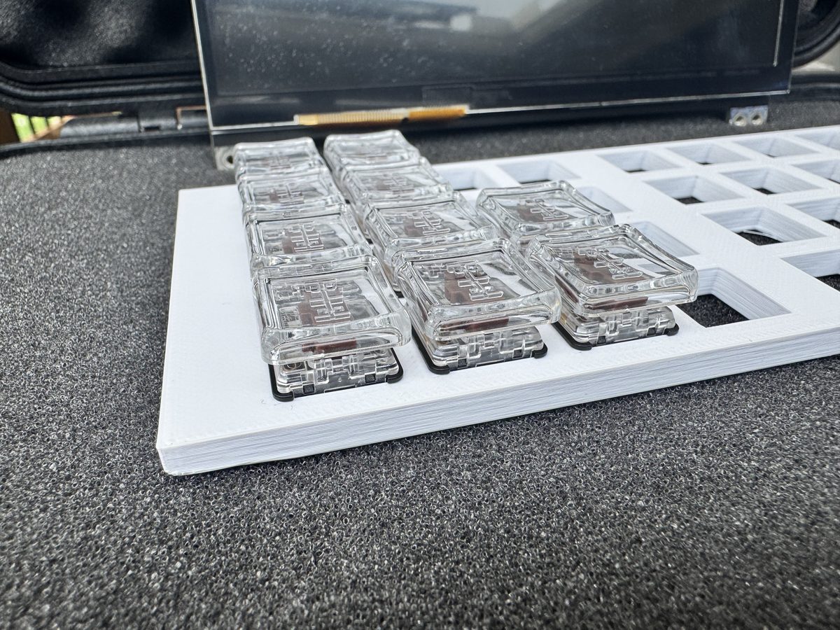 Close-up of Kailh Choc mechanical switches mounted on a white 3D-printed key plate — the first physical prototype of the KN-86 keyboard